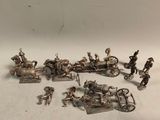 figurines en argent représentant une calèche tirée par des chevaux avec des passagers à bord