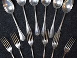 six cuillères et six fourchettes en argent sont disposées en cercle