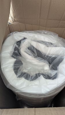a cardboard box with a toilet in it that is wrapped in plastic