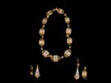 un gros plan d'un collier et de boucles d'oreilles sur fond noir
