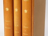 trois livres sont posés dans une boîte sur une surface blanche