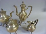 a silver tea set on a white table cloth
