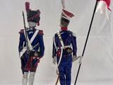 pair of figurines of two soldiers holding flags and a flag
