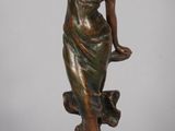 statue en bronze d'une femme tenant un oiseau sur une base en bois
