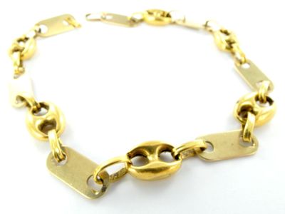 gros plan d'un bracelet en chaîne en or sur une surface blanche