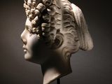 marble bust of a woman with curly hair on a marble base