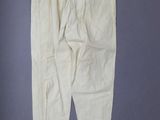 an old pair of white pants hanging on a wall