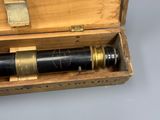 un vieux télescope dans une boîte en bois posée sur une table