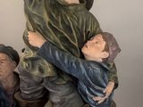 a figurine of a man holding a child on top of a statue