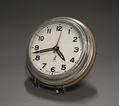 a clock that is sitting on a stand on a table