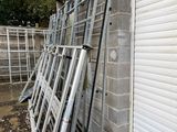 a pile of metal ladders leaning against a building