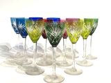 six wine glasses lined up in a row on a white surface