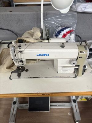 une machine à coudre blanche posée sur une table dans une pièce