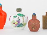 quatre vases de couleurs différentes posés les uns à côté des autres sur une surface blanche