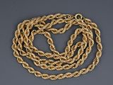 a gold rope necklace on a gray background