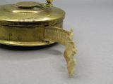 une petite boîte en laiton entourée d'un ruban
