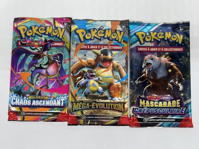 three packs of pokemon trading cards are on a white surface