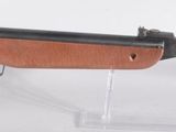 fusil exposé sur un socle en acrylique transparent, sur fond blanc