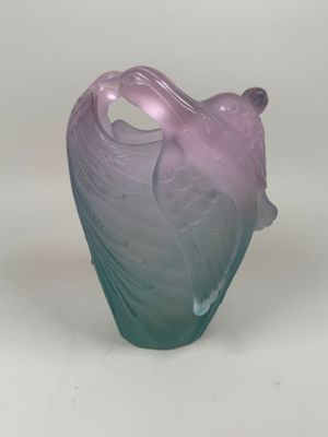 un vase violet et bleu posé sur une surface blanche