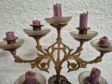 a gold candelab with purple candles on top of it