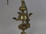 a brass plated lamp with a glass shade on top of it