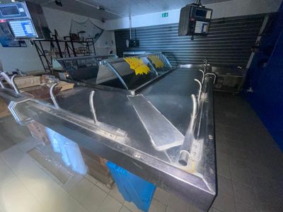 un comptoir en métal sur lequel est posé un bouquet de fleurs jaunes