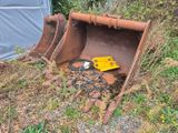 un seau posé dans l'herbe à côté d'un bâtiment