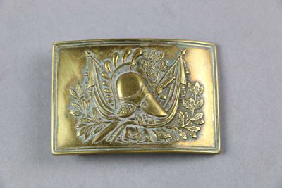 a gold belt buckle with a picture of a bird on it