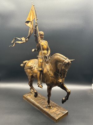 bronze statue of a man on a horse holding a flag