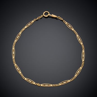 un bracelet en chaîne d'or avec des maillons et un fermoir, sur fond noir