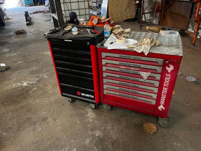une boîte à outils rouge posée sur une table dans un garage