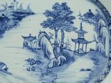 a blue and white plate with a painting on it
