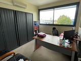 un bureau avec un ordinateur et une chaise dans une pièce