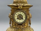 a gold clock that is sitting on top of a table