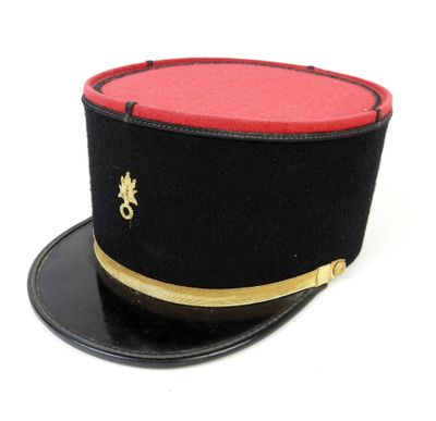 un chapeau noir avec un dessus rouge et des bordures dorées
