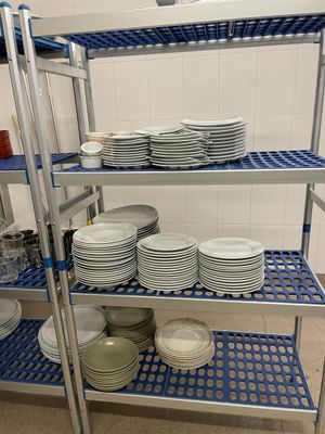 beaucoup d'assiettes et de bols sur les étagères de la cuisine