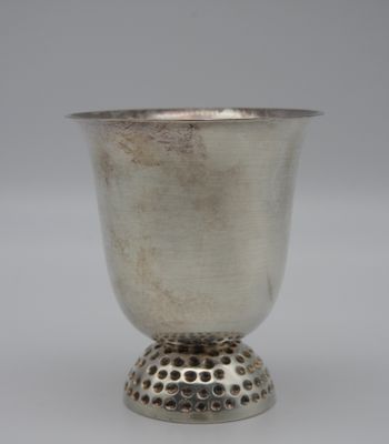une coupe ancienne en argent posée sur un socle en métal