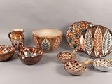 many different pieces of pottery sitting on a table