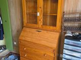 un meuble en bois avec une porte en verre dans une pièce