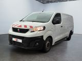 La petite camionnette blanche est garée dans une grande pièce.