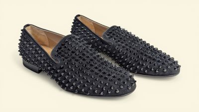 a pair of black spiked shoes on a white background
