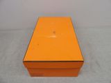an orange box sitting on top of a white table next to a white wall