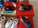several pairs of baby shoes are lined up in a row on a bed