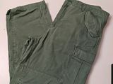 un pantalon vert posé sur une table à côté d'un téléphone portable