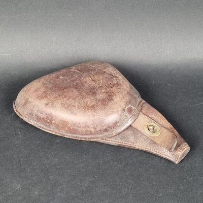 un chapeau en cuir marron posé sur une surface noire