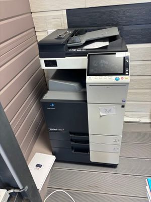 a printer sitting on top of a desk next to a monitor
