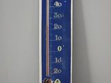 un thermomètre bleu et blanc accroché au mur