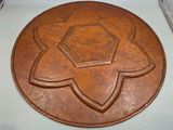 an image of a brown leather plate with a flower design on it