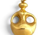an image of a gold plated pendant with a face on it