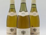 trois bouteilles de vin sont alignées sur une surface blanche